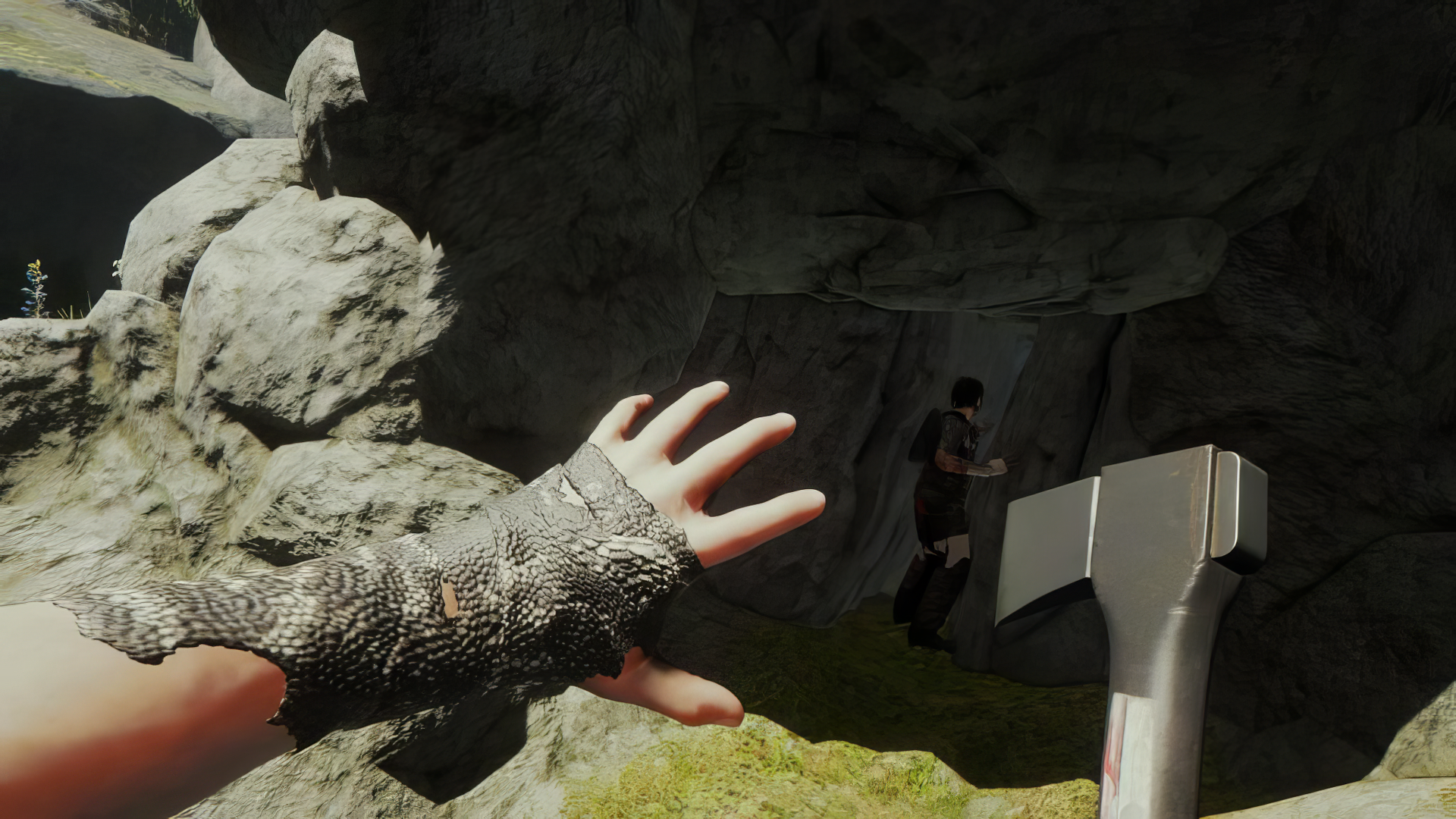 Sons of the Forest game screenshot showing a first-person view of a player with an axe approaching a cave entrance for HD wallpaper.