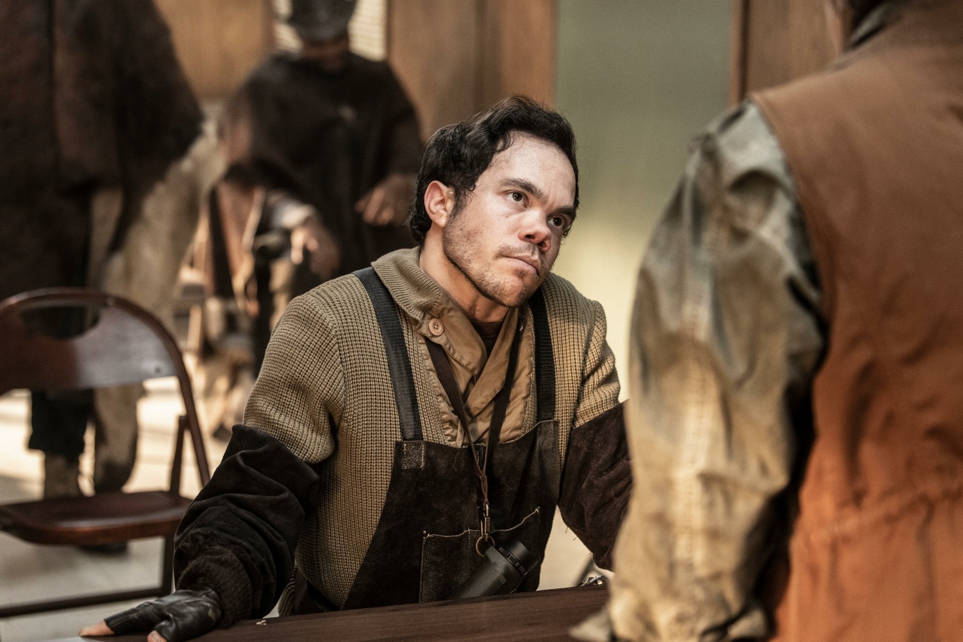 A scene from The Walking Dead: The Ones Who Live, featuring a character in a gritty setting, surrounded by others, captured in detailed HD for a striking desktop wallpaper.