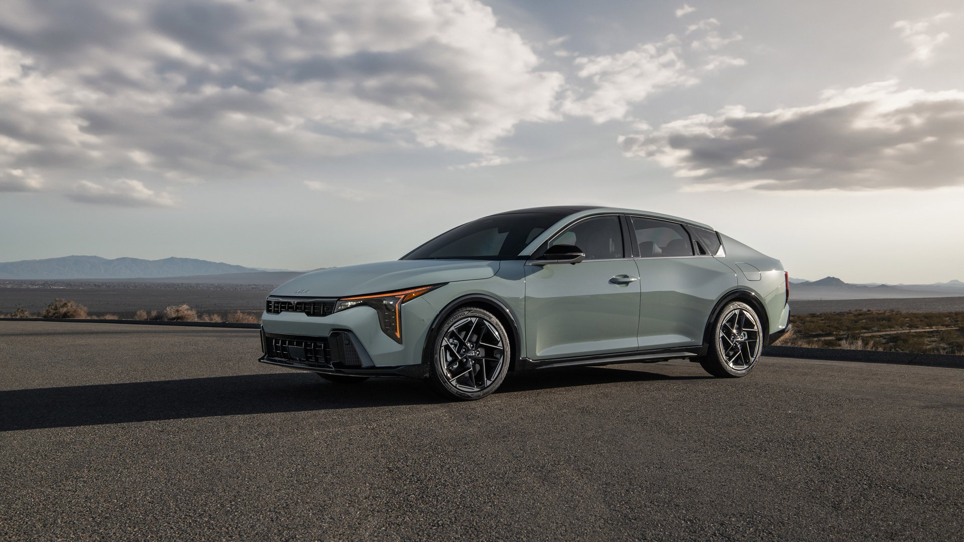 A sleek Kia K4 GT-Line parked on an open road, set against a dramatic sky. This HD desktop wallpaper showcases the car's stylish design and modern features.