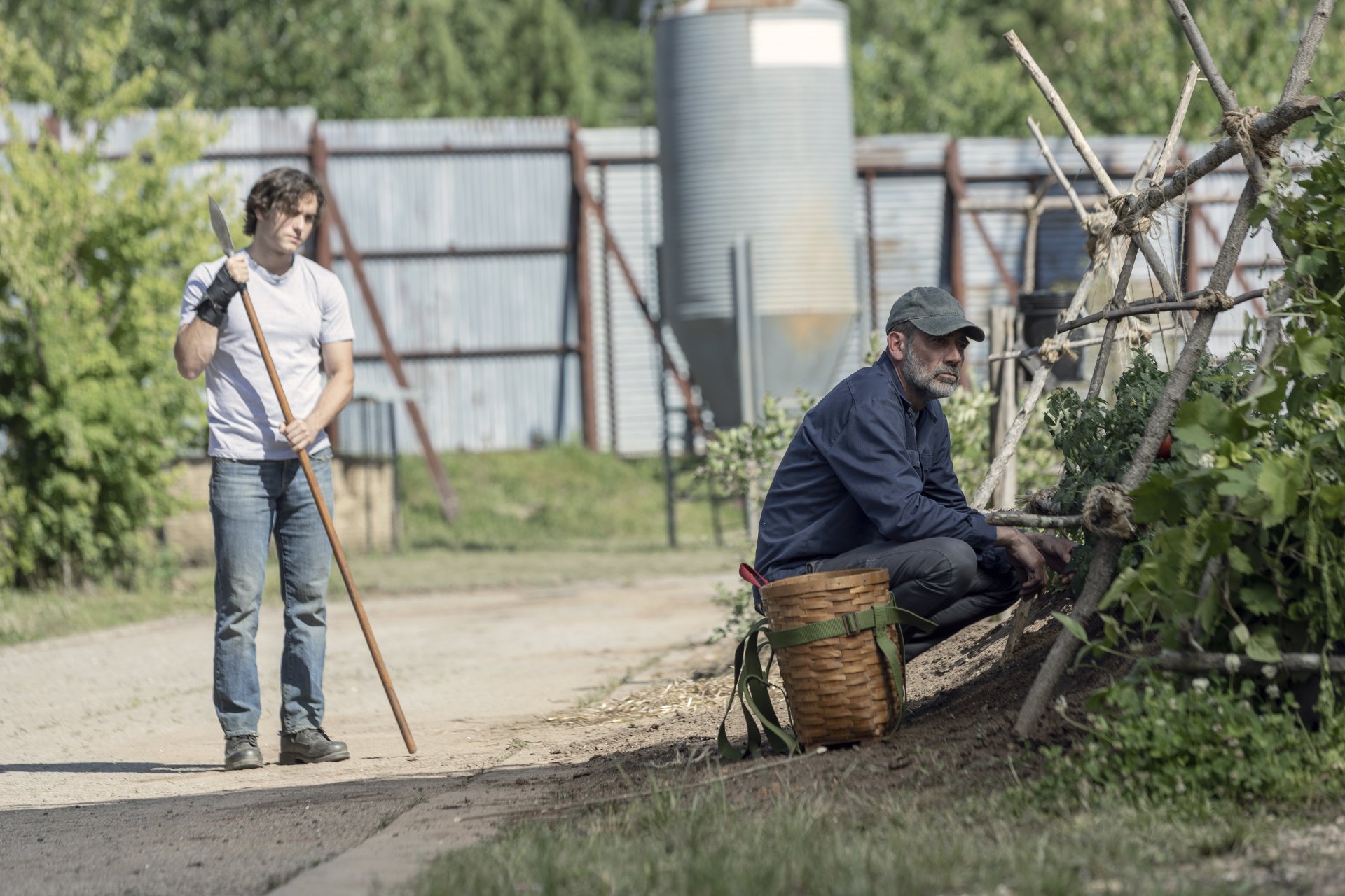 Two characters from The Walking Dead TV show engaged in outdoor work in a serene setting, available as an HD desktop wallpaper and background.