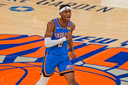 Shai Gilgeous-Alexander celebrates on the court in a vibrant Oklahoma City Thunder uniform, showcasing his passion for basketball in this dynamic NBA action wallpaper.
