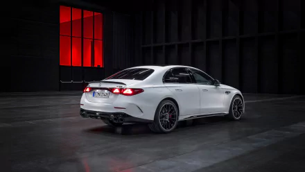 White Mercedes-AMG E53 Hybrid car showcased as a high-definition desktop wallpaper with a stylish red-lit background.