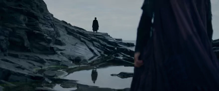 HD wallpaper featuring a scene from the TV show The Acolyte (2024) with a mysterious figure standing on a rocky landscape reflected in water.