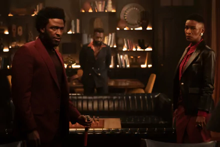 HD wallpaper of two characters from the 2024 TV show Parish standing in a dimly lit room with vintage decor.