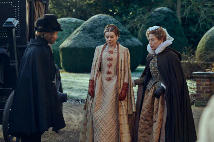 HD desktop wallpaper of three characters from the TV show Mary & George conversing in a historical setting with manicured hedges in the background.