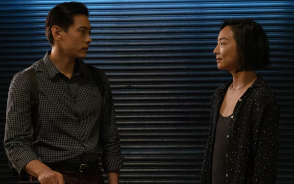 HD desktop wallpaper featuring two individuals from the movie Past Lives standing and facing each other with a textured dark blue background.