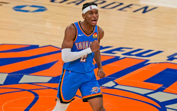 Shai Gilgeous-Alexander celebrates on the court in a vibrant Oklahoma City Thunder uniform, showcasing his passion for basketball in this dynamic NBA action wallpaper.