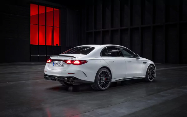 White Mercedes-AMG E53 Hybrid car showcased as a high-definition desktop wallpaper with a stylish red-lit background.