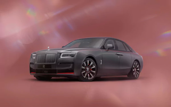 A sleek Rolls-Royce Ghost stands prominently against a soft pink background, showcasing its luxury design in this high-definition desktop wallpaper.