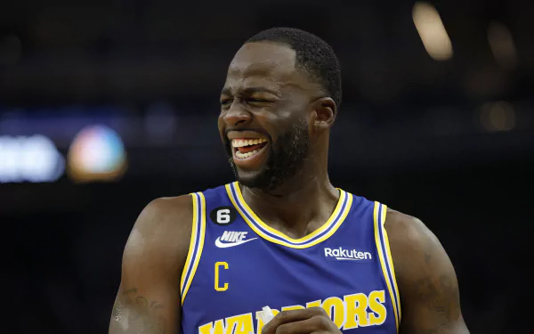 Draymond Green of the Golden State Warriors shares a joyful moment during a game, captured in this vibrant HD wallpaper that showcases his dynamic energy and spirit.
