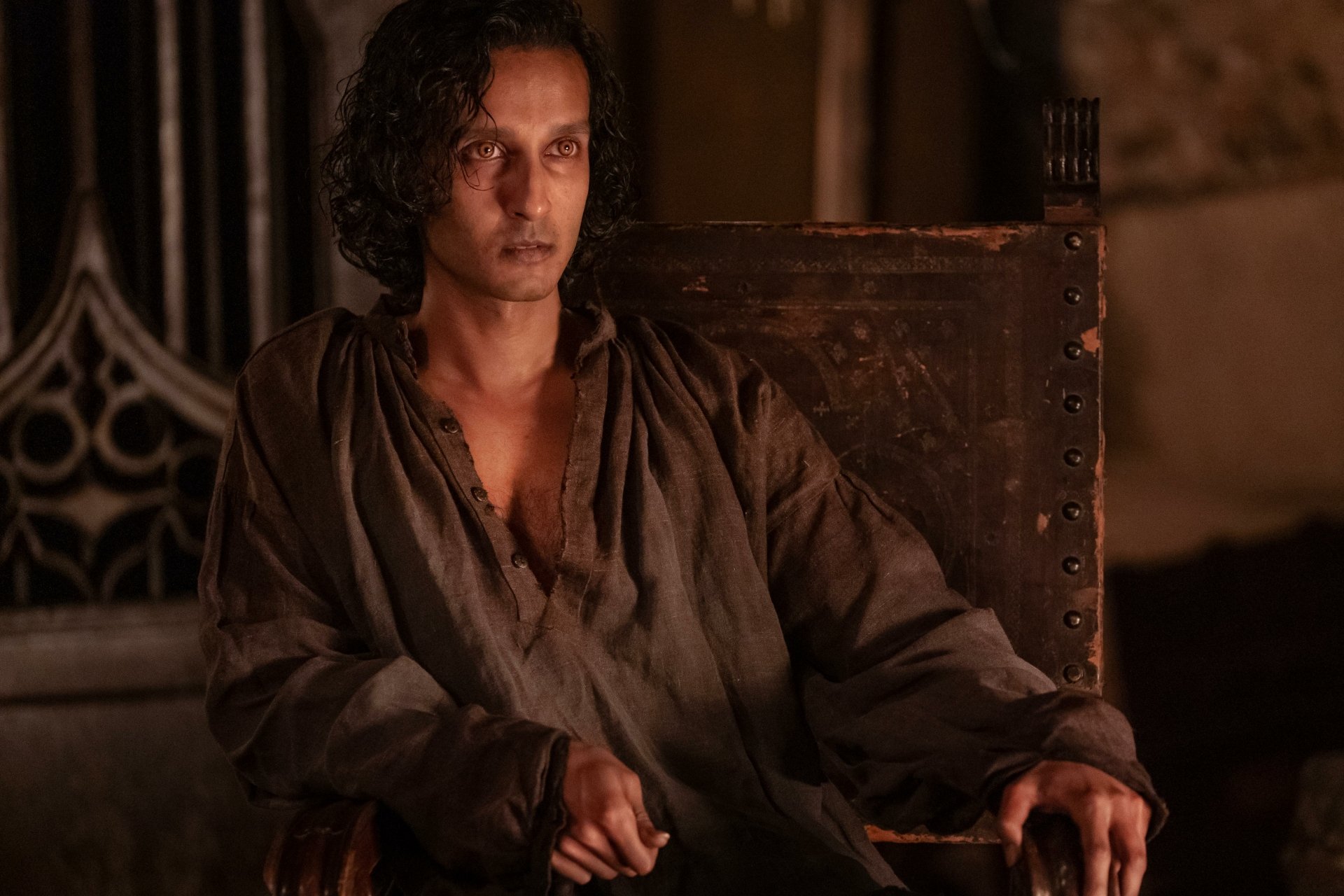 Alt Text: High-definition wallpaper featuring a character from the TV show Interview with the Vampire, seated in a dim, ornate room, exuding a mysterious aura.