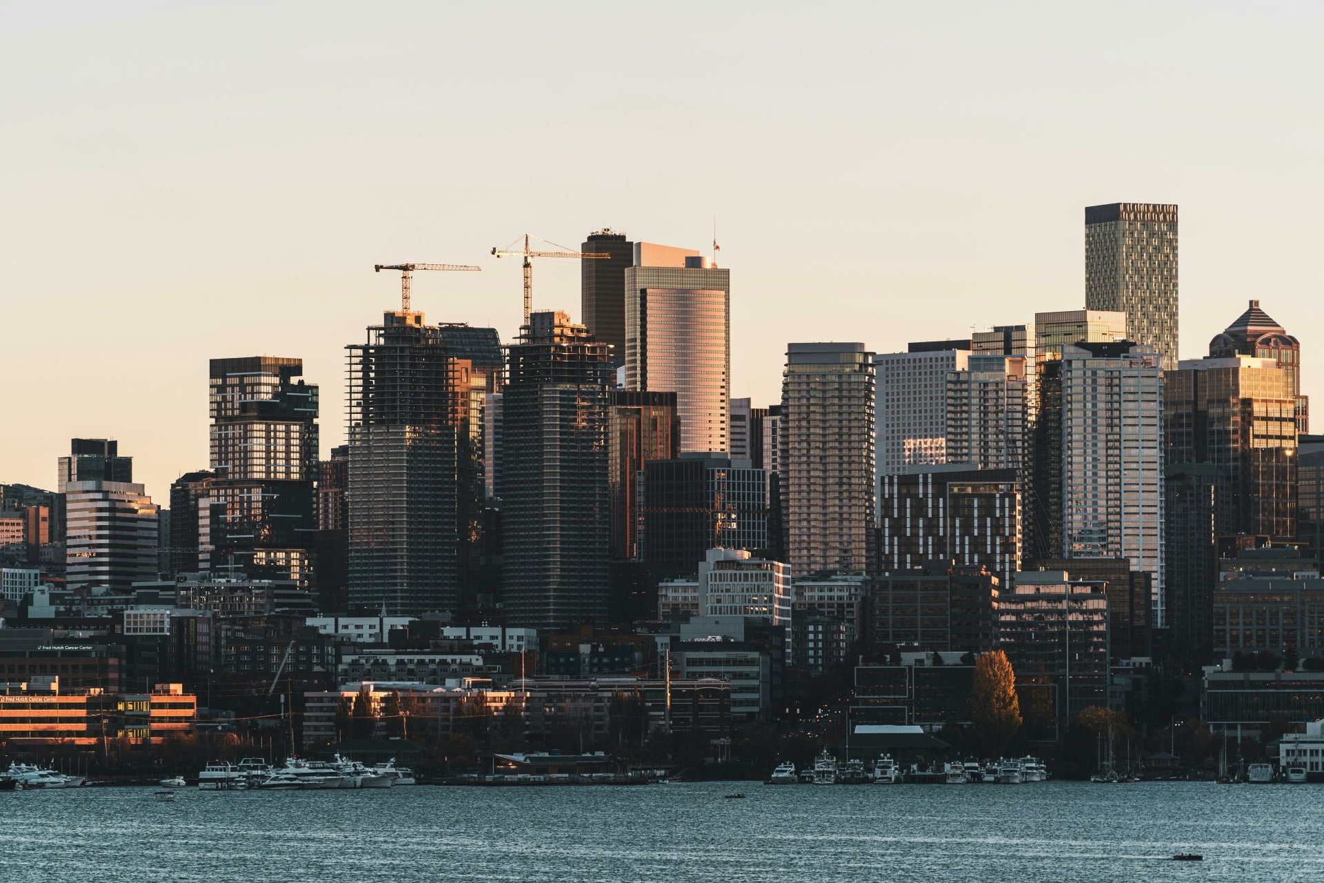 HD desktop wallpaper of downtown Seattle's skyline with modern buildings and skyscrapers lit by soft light, featuring a view of the waterfront.