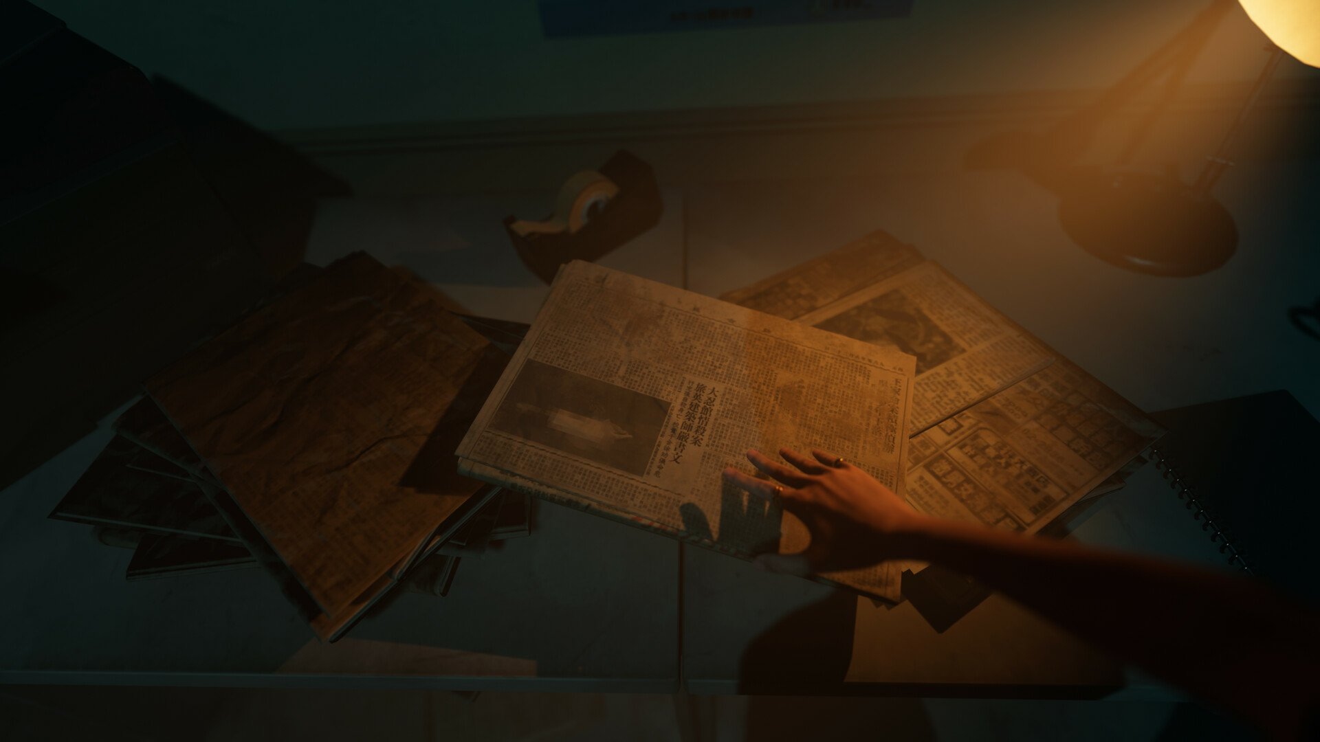 A hand reaches for scattered newspapers under dim lighting in a scene from the video game The Bridge Curse 2: The Extrication. This HD desktop wallpaper evokes a mysterious and eerie atmosphere.