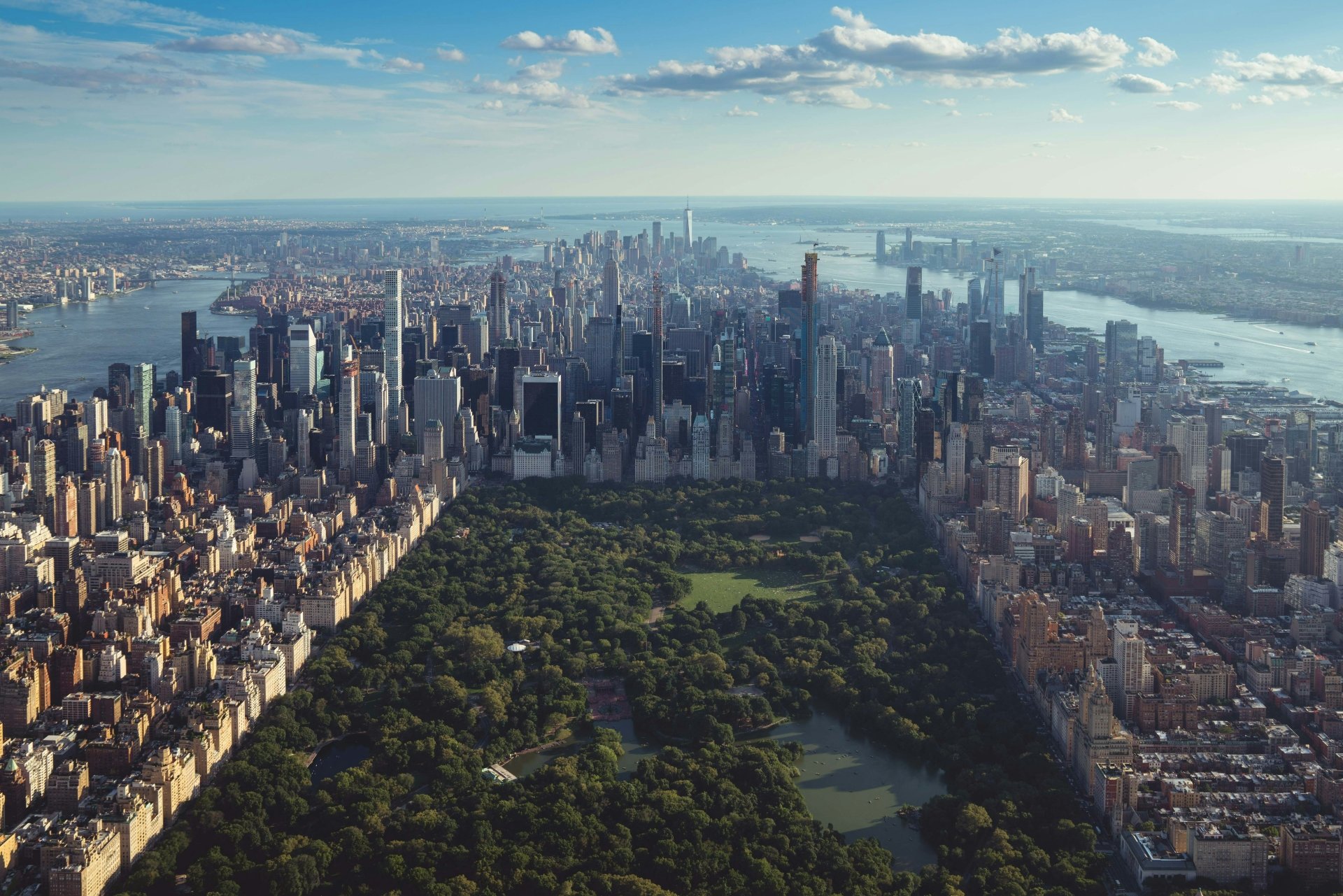 Aerial view of New York City, showcasing Central Park surrounded by skyscrapers and urban landscape. This HD desktop wallpaper and background captures the city's vibrant and iconic skyline.