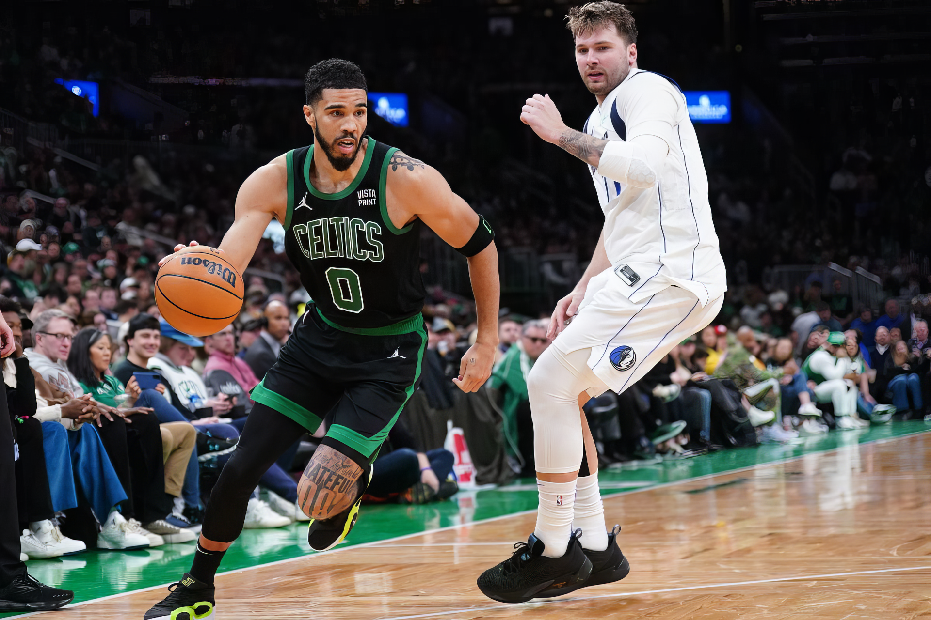 NBA stars Luka Dončić of the Dallas Mavericks and Jayson Tatum of the Boston Celtics in action during a game. This HD wallpaper captures the intensity of their performance on the court.