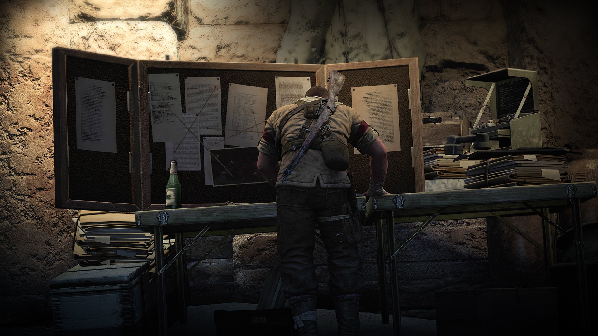 HD desktop wallpaper and background featuring Sniper Elite III, showcasing a character intently studying plans on a table laden with documents and maps in a dimly lit setting.