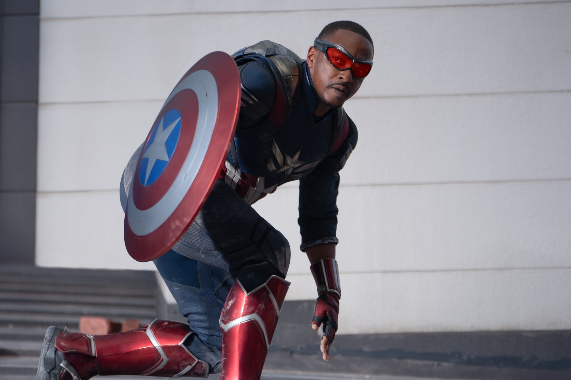 HD wallpaper of Anthony Mackie as Captain America in Captain America: Brave New World, featuring a dynamic action pose with his shield.