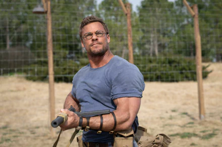 HD wallpaper of Alan Ritchson from The Ministry of Ungentlemanly Warfare, showcasing the actor in a combat-ready pose.