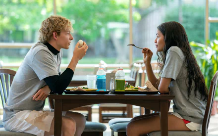 HD desktop wallpaper from Challengers (2024) featuring a young man and woman eating and talking at a cafeteria table.