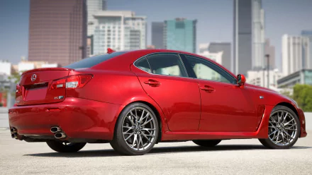 A high-definition wallpaper of a red Lexus IS F parked in an urban setting with city buildings in the background.