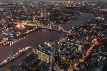 A stunning HD desktop wallpaper of London, United Kingdom, featuring a breathtaking aerial view of the city illuminated at night with prominent buildings and the Thames River in the background.