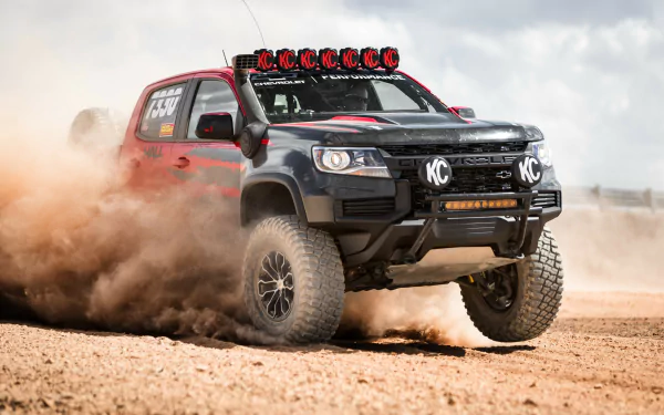 A rugged desert landscape featuring a Jeep off-road vehicle amidst golden sand dunes, creating a stunning HD desktop wallpaper and background.