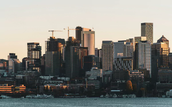 HD desktop wallpaper of downtown Seattle's skyline with modern buildings and skyscrapers lit by soft light, featuring a view of the waterfront.