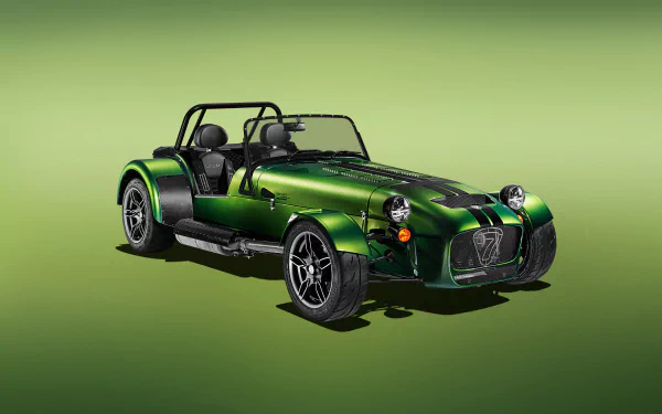 A high-definition desktop wallpaper featuring a green Caterham Seven 485 sports car on a smooth gradient green background.