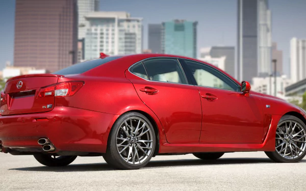 A high-definition wallpaper of a red Lexus IS F parked in an urban setting with city buildings in the background.