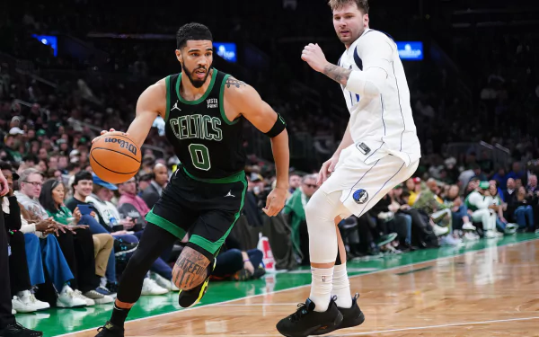 NBA stars Luka Dončić of the Dallas Mavericks and Jayson Tatum of the Boston Celtics in action during a game. This HD wallpaper captures the intensity of their performance on the court.