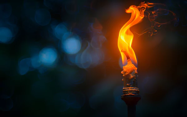 Close-up HD image of a torch with a vibrant flame against a dark, blurred background.