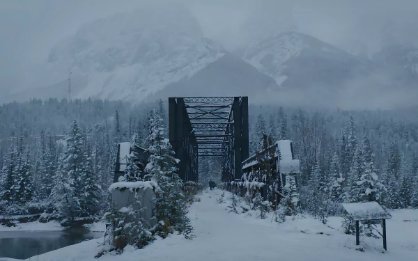 Snow-covered bridge set against misty mountains in a scene from The Last Of Us, rendered in stunning 8K Ultra HD for PC desktop wallpaper and background.