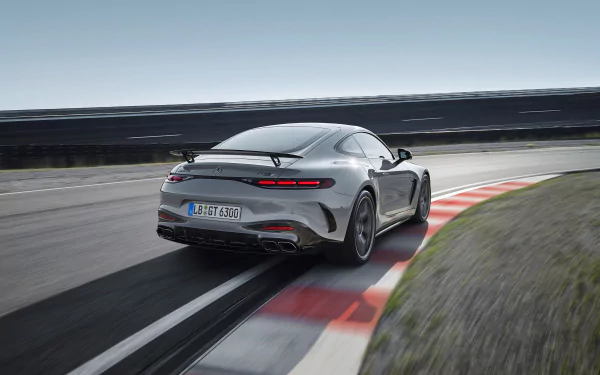 HD desktop wallpaper featuring a Mercedes-AMG GT63 PRO, showcasing its sleek design as it navigates a racetrack curve under a clear sky.
