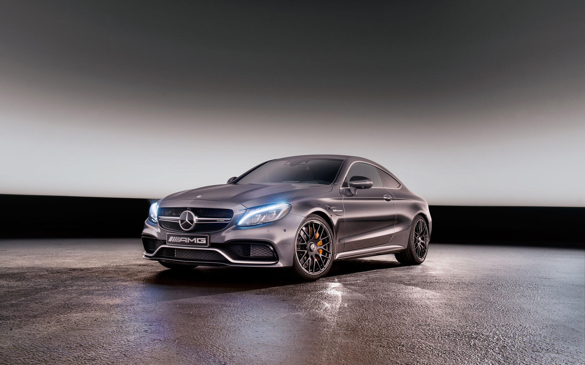 HD desktop wallpaper featuring a sleek Mercedes-Benz C63 AMG in a modern, dimly lit setting showcasing its powerful design and AMG performance heritage.