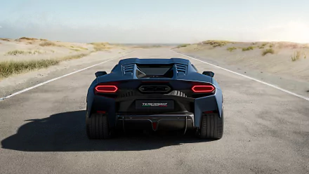 A sleek Lamborghini Temerario sports car showcased from the rear, set against an open desert road, serving as a striking HD desktop wallpaper.