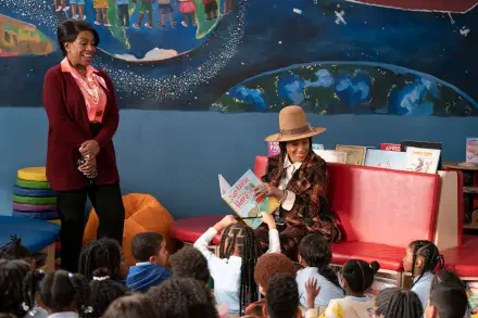 A scene from the TV show *Abbott Elementary*, featuring two teachers engaging with young students during storytime in a colorful classroom setting.