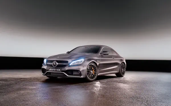 HD desktop wallpaper featuring a sleek Mercedes-Benz C63 AMG in a modern, dimly lit setting showcasing its powerful design and AMG performance heritage.