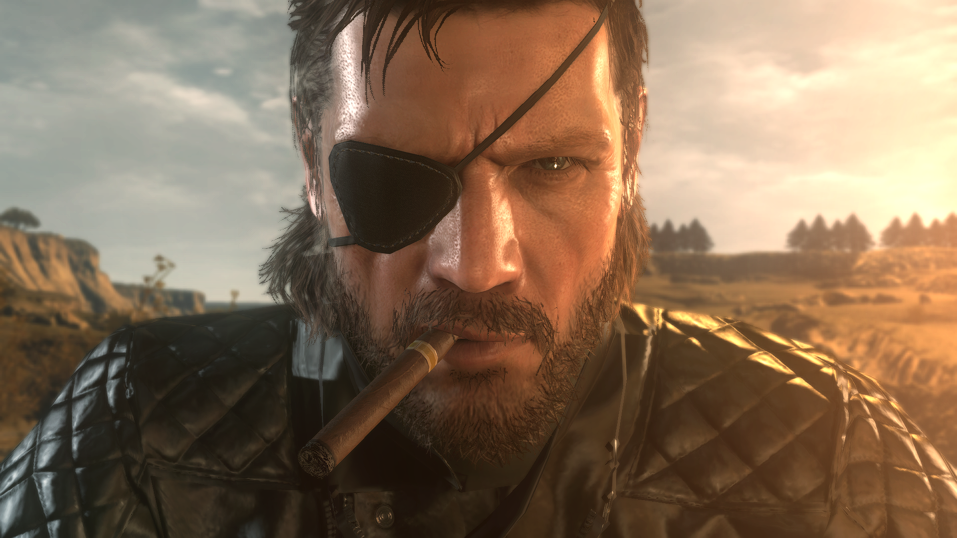 Close-up of Big Boss from Metal Gear Solid V: The Phantom Pain, showcasing intense expression and iconic eyepatch, set against a backdrop of a dramatic landscape. HD PC wallpaper quality.