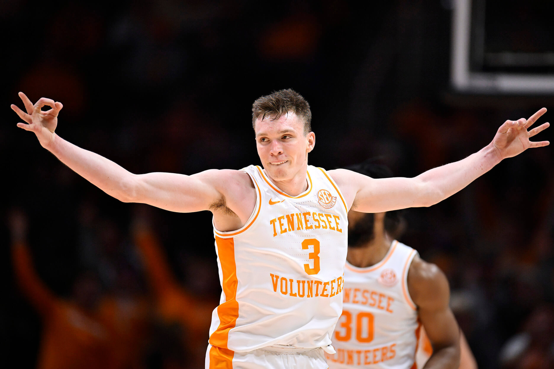 Dalton Knecht celebrates during a basketball game, showcasing his skills in a dynamic pose, wearing the Tennessee Volunteers uniform. A vibrant image capturing sports energy.