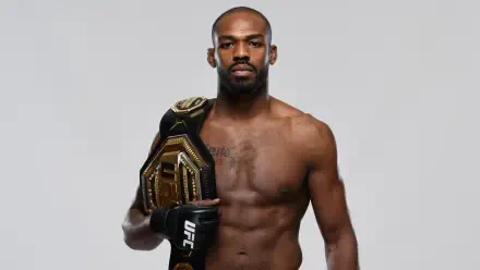 Jon Jones stands proudly holding his championship belt, showcasing his status in UFC and MMA. This dynamic 4K Ultra HD image captures the intensity of the sport.