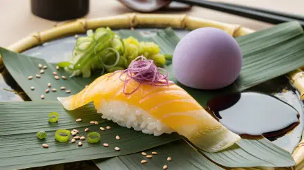 A beautifully presented piece of sushi, topped with purple onion, alongside fresh green garnishes and a lavender egg, showcased in a vibrant 4K Ultra HD desktop wallpaper.