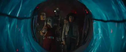 A group of characters from the TV show Star Wars: Skeleton Crew stands together, framed by a glowing portal, ready for their next adventure in a vibrant galaxy.