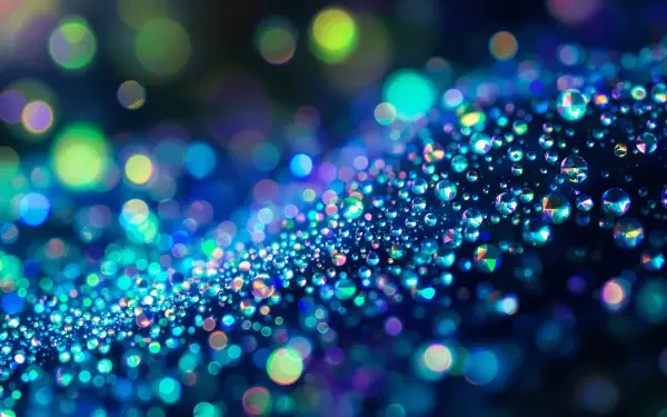 A stunning 4K Ultra HD desktop wallpaper featuring vibrant blue and green droplets glistening on a soft surface, creating a mesmerizing and colorful bokeh effect.
