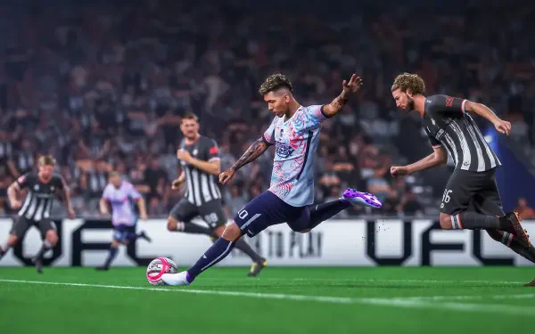 A dynamic scene from the video game UFL, featuring a player striking a soccer ball on a vibrant pitch, surrounded by teammates and opponents in an intense match setting.