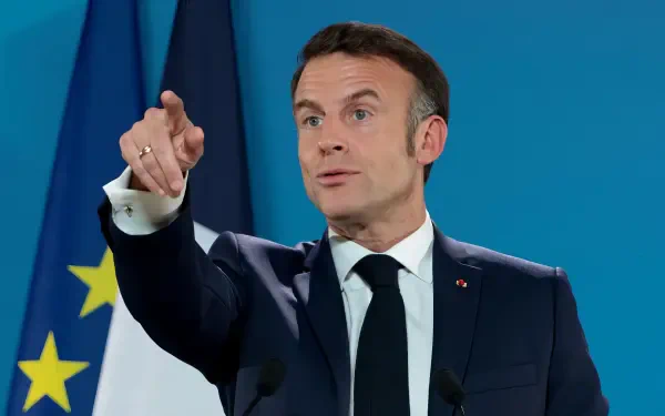 Emmanuel Macron gestures during a speech, with the French flag in the background. This high-definition image serves as a striking desktop wallpaper and background.