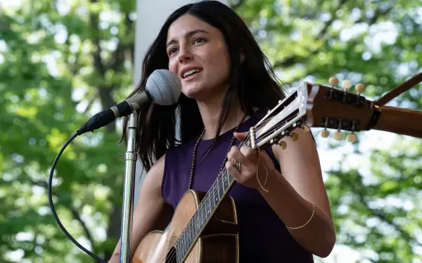 Monica Barbaro performs as a singer in a vibrant outdoor setting, captured in this 8K Ultra HD image inspired by the movie A Complete Unknown.