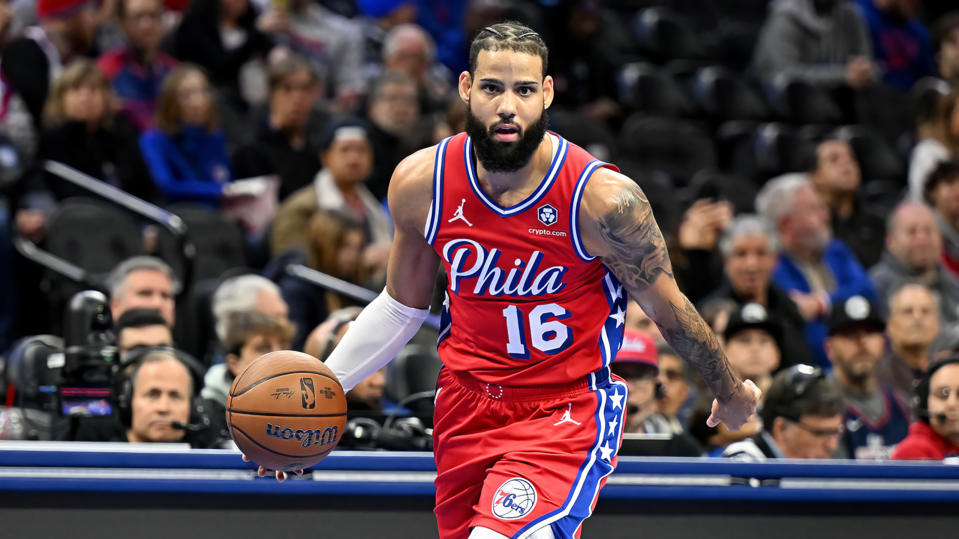 Caleb Martin dribbles the basketball during an NBA game for the Philadelphia 76ers, showcasing his skills on the court in an engaging sports scene.