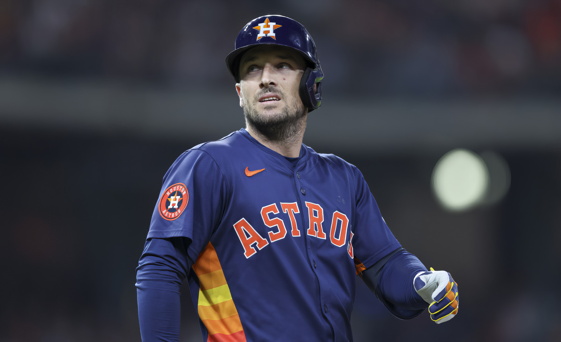 Alex Bregman of the Houston Astros, adorned in his team's orange and navy uniform, stands confidently on the field during an MLB game, showcasing the spirit of baseball.