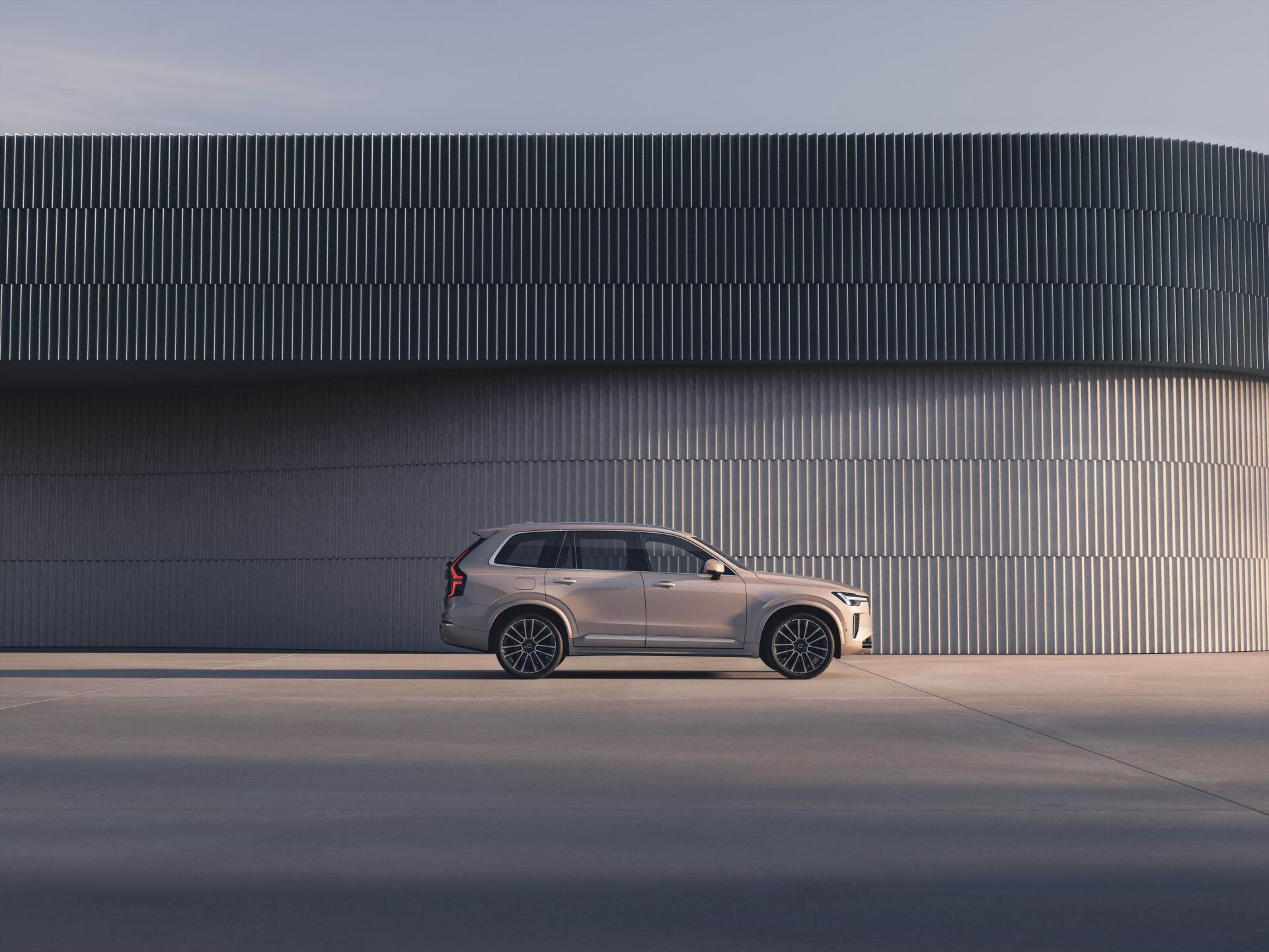 A sleek Volvo XC90 Facelift parked alongside a modern architectural structure, showcased in a 4K Ultra HD resolution for a striking desktop wallpaper.