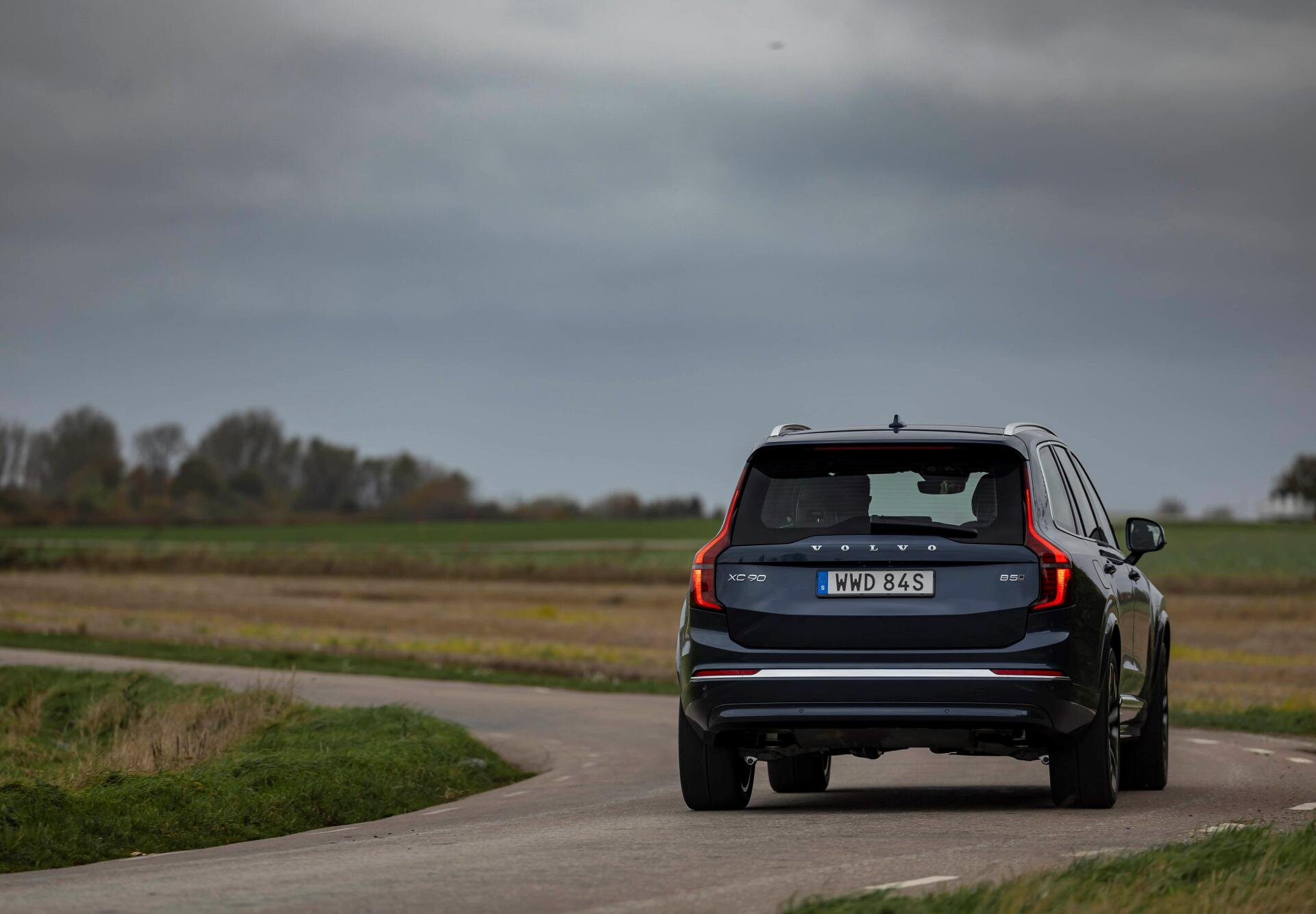 A sleek Volvo XC90 Facelift drives along a winding road, set against an expansive landscape, captured in stunning 4K Ultra HD for a captivating desktop wallpaper.